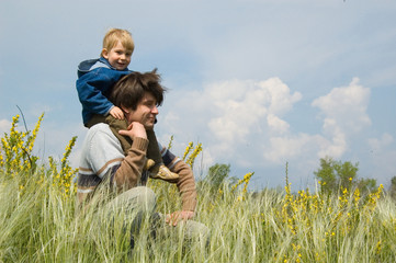 Naklejka na ściany i meble happy father and little son rst on the field of feather-grass