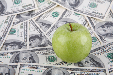 Green apple on a one hundred dollar bills