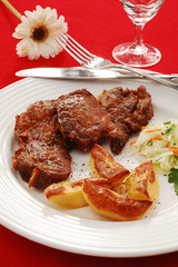 Grilled meat with baked potatoes and vegetable salad