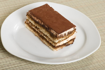 tiramisu on a plate with a bamboo mat