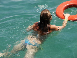 Mulher nadando com bóia e snorkle no mar