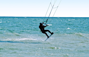 Silhouette of a kitesurfer on waves of a sea