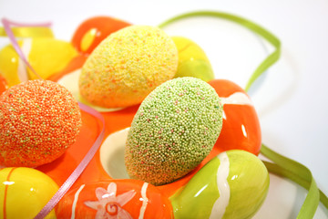 Egg shaped dish holding colorful Easter eggs