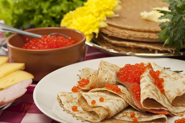 served place setting: pancake with red caviar and greens