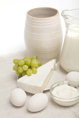 Breakfast with cheese and green grapes on white background