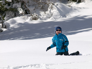Fototapeta na wymiar boy playing in the snow on the mountain