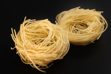 Raw pasta nests on black