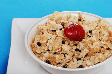 bowl of cereal with blueberries and a strawberry