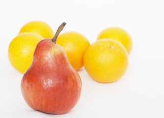 Oranges behind a red pear