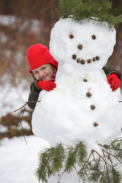 Little girlposing with snowman