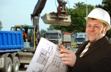 Ingenieur mit Bauplan und Helm auf der Baustelle