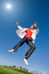 Happy young man - jumping  end flies in blue sky