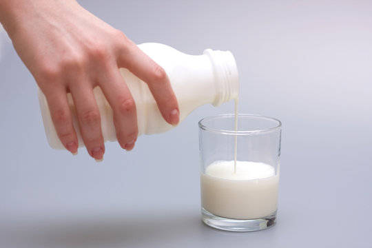 Female hand pouring milk in glass