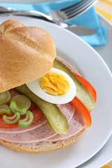 belegtes brötchen mit bierwurst, ei, gurke und tomate
