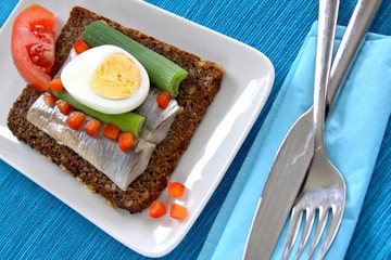 belegtes brot mit hering, ei, zwiebel und tomate