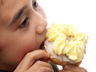 sweet sensation, child biting on a cake with with butter creme