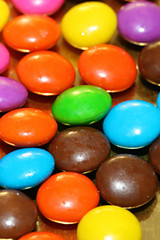 A pile of chocolate candies with a colorful outer shell