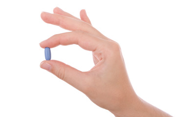 Hand holding a blue pill isolated on white