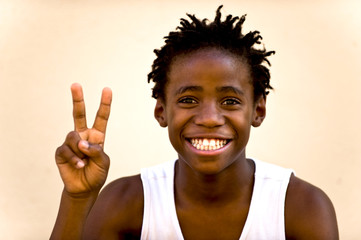 Junge zeigt ein peace Zeichen mit den Fingern