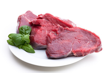 Rotes Fleisch auf weißem Teller mit Garnierung