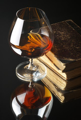Glass of cognac and books
