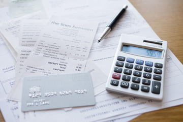 Credit card, calculator & pen on receipts