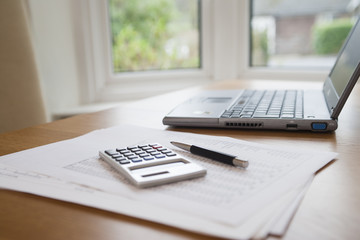 Pen , laptop, calculator on table