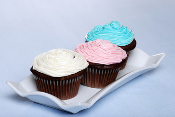 white pink blue frosted chocolate cupcakes