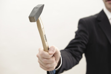 mann im anzug hält hammer