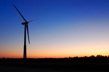 Wind turbine against an evening glow background