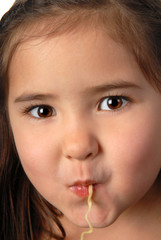 Young girl slurping a noodle