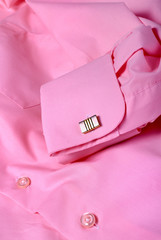 Close-up of cufflink on pink shirt