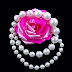 Pearl necklace and bow for gift on black background