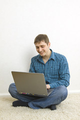 man sitting on the floor using a laptop