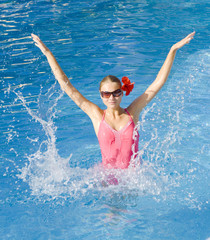 Girl in pink swimsuit playing with water