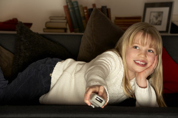 Obraz premium Young Girl Using Television Remote Control