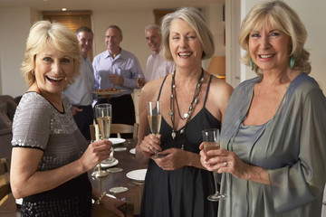 Friends Enjoying A Glass Of Champagne At A Dinner Party
