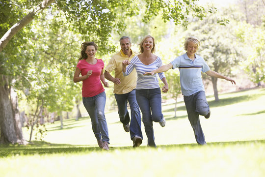 Family Running Through A Park