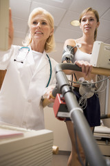 Doctor Monitoring The Heart-Rate Of Patient On A Treadmill