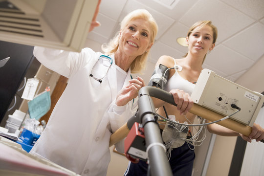 Doctor Monitoring The Heart-Rate Of Patient On A Treadmill