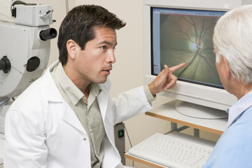 Doctor Explaining Eye Exam Results To Patient