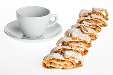 Tasse und Apfelstrudel-Scheiben mit Puderzucker