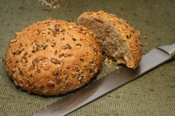 A whole-grain roll  with bread  knife