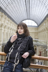 young attractive woman eating ice-cream  standing at railing in