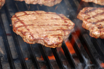 BBQ hamburger on the grill with flames