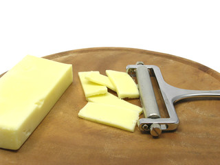 Hartkäse auf Holzteller mit Käsehobel