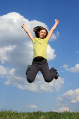 Girl jumping, running against blue sky