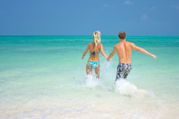 A young couple walking through the waves