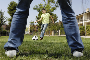 father and son playing football