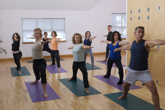 Teacher Guides Student In Yoga Class